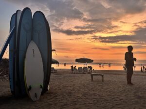 pobudź swoją kreatywność i rób piękne zdjęcia teleofnem - pamiątka z wakacji zachód słońca na Bali z deskami serfingowymi